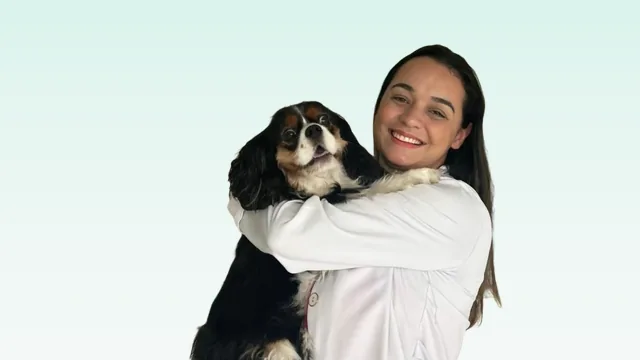 Veterinária da Spadacini abraçando um cão da raça cavalier